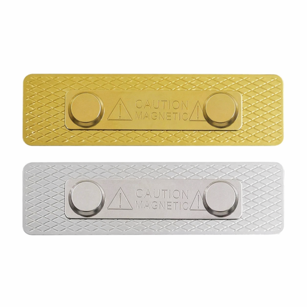 Two rectangular magnetic plates gold and silver with diamond pattern texture and a central warning panel reading caution magnetic and circular magnets on each end